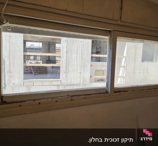 חלון עם נוף של אתר בנייה בחוץ